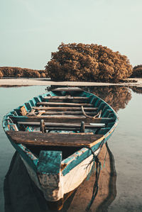 Boat moored in lake against sky