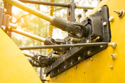 Close-up of yellow machine part outdoors