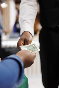 Midsection of businessman giving paper currency