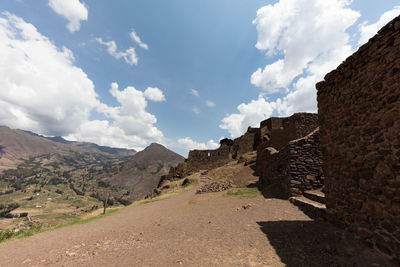 Road by mountains against sky