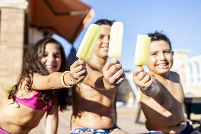 Three funny kids showing their ice lollies