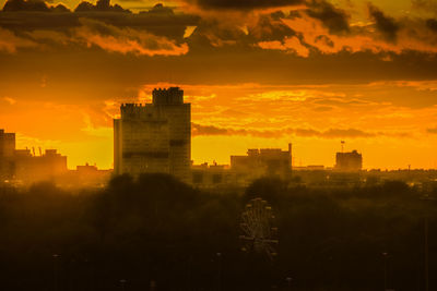 Buildings in city at sunset