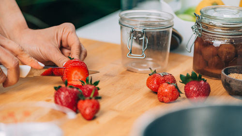 Cutting strawberries in the kitchen. homemade fruit canning preservation.