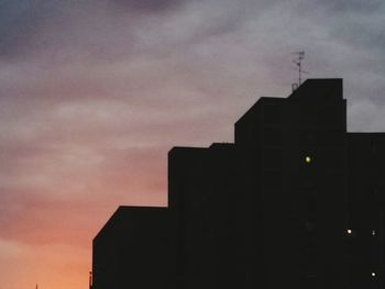 Low angle view of silhouette buildings against sky at dusk