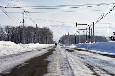 Snow covered road against sky