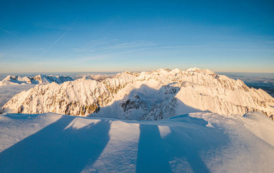 Scenic view of snowcapped mountains against blue sky