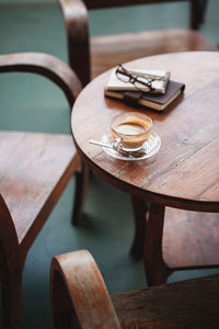 High angle view of coffee cup by books on table