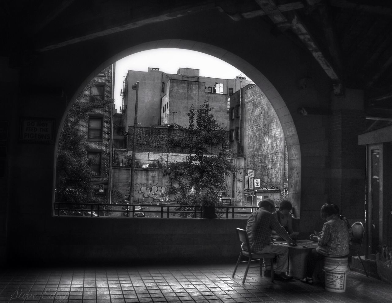 indoors, architecture, arch, built structure, window, building exterior, entrance, tree, day, archway, men, history, person, full length, building, gate, architectural column, glass - material, sitting