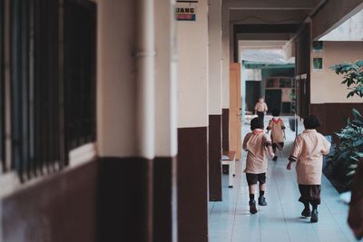 Rear view of people walking in corridor