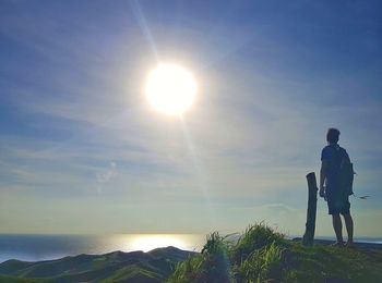 Man standing on sunny day against sky