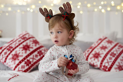 Cute baby girl on bed at home