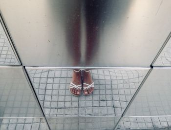 Low section of woman standing on tiled floor