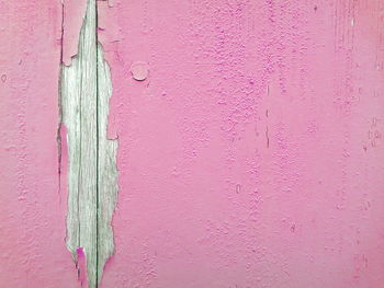 Pink peeled paint on wooden plank