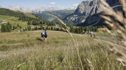 People walking on land leading with mountains in background