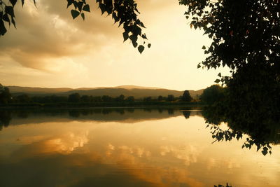 Scenic view of lake against sky at sunset