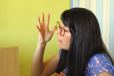 Portrait of woman against wall at home