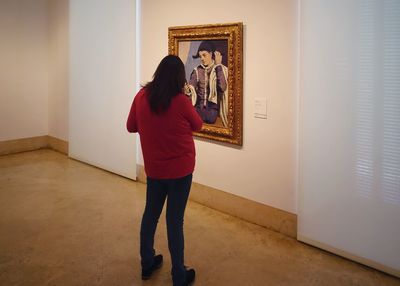 Rear view of woman standing against wall at home