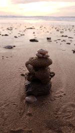 Close-up of stone stack on sand at beach