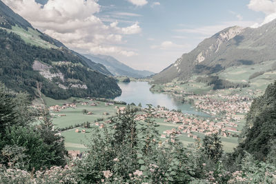 Scenic view of lake by mountains against sky