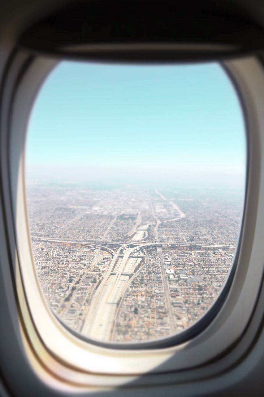 AERIAL VIEW OF CITY SEEN THROUGH AIRPLANE WINDOW