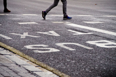 Low section of person walking on road