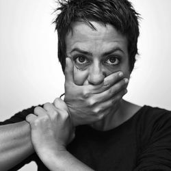 Close-up of woman covering face over white background