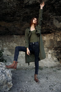 Portrait of young woman standing on rock