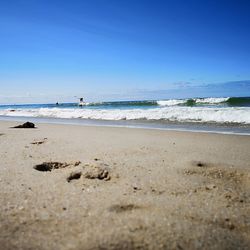 Scenic view of beach against clear blue sky