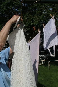 Side view of woman arranging wedding dress on clothesline