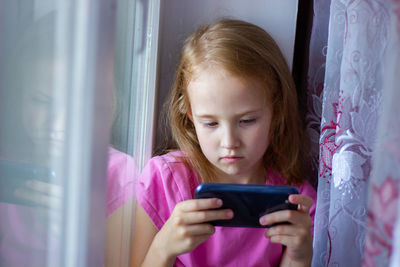 Portrait of a beautiful girl with a mobile phone. cute girl watching cartoon on the mobile phone.