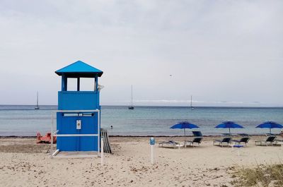 Lifeguard hut on beach against sky