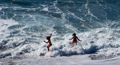 High angle view of girls jumping at beach