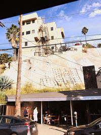 People in front of building against sky