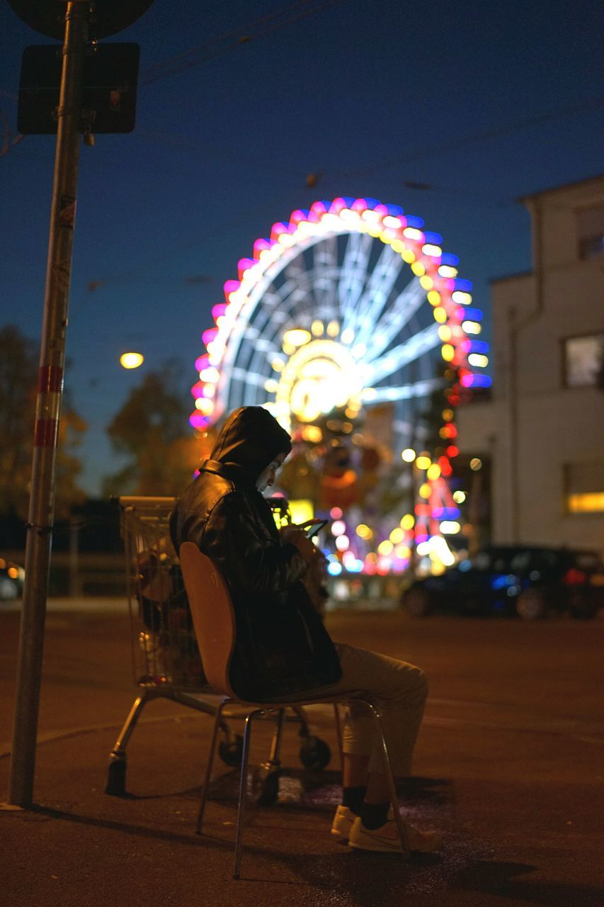 leisure activity, illuminated, arts culture and entertainment, lifestyles, amusement park, amusement park ride, night, men, full length, ferris wheel, enjoyment, fun, rear view, person, built structure, holding, sky, playing