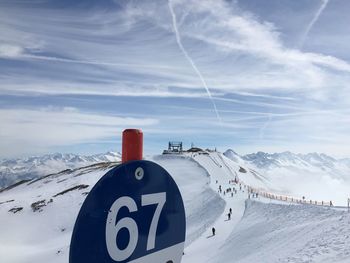 Information sign on snow against sky