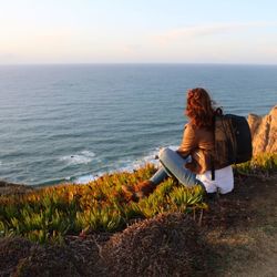 Rear view of woman looking at sea against sky