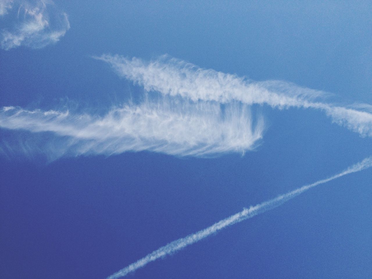 blue, low angle view, sky, beauty in nature, cloud - sky, nature, scenics, tranquility, vapor trail, tranquil scene, cloud, day, outdoors, no people, sky only, idyllic, white color, backgrounds, copy space, cloudscape