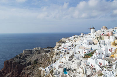 High angle view of townscape by sea against sky