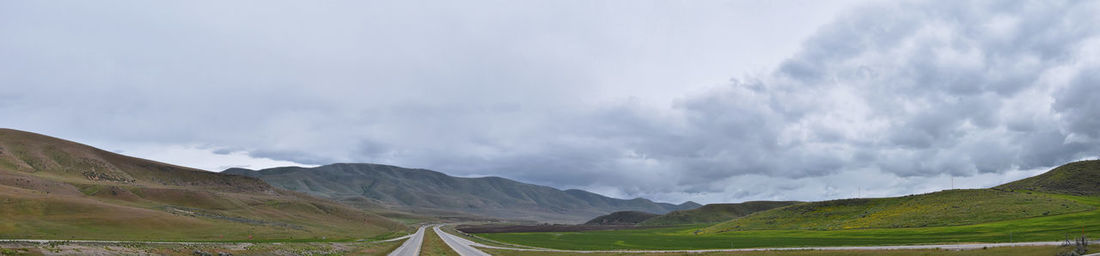 Panoramic view of road amidst mountains against sky