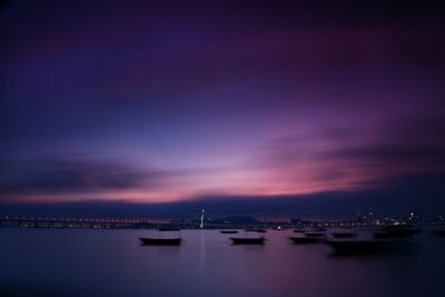 Boats in sea against sky at twilight