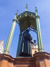 Low angle view of statue against blue sky