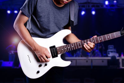 Midsection of man playing guitar