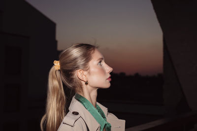 Young woman standing against black background