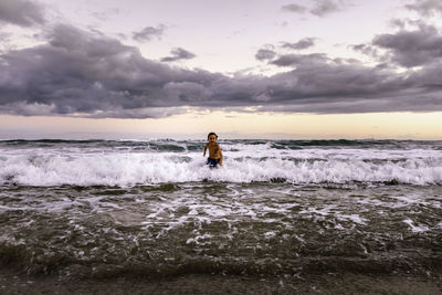 Happy 5 years old kid running in the sea