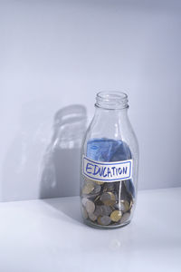 Close-up of glass jar on table against white background