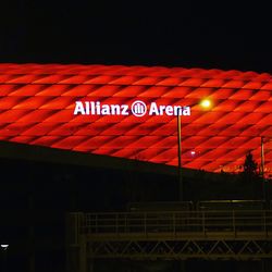 Low angle view of illuminated sign against sky at night