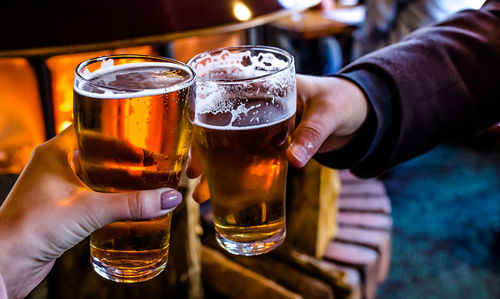 Cropped image of hand holding beer glass