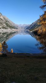 Scenic view of lake and mountains against blue sky