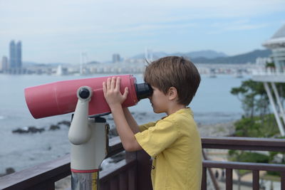 Boy looking through coin-operated binoculars
