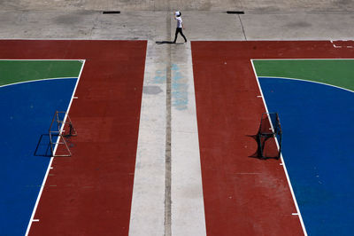 High angle view of man walking on footpath in court